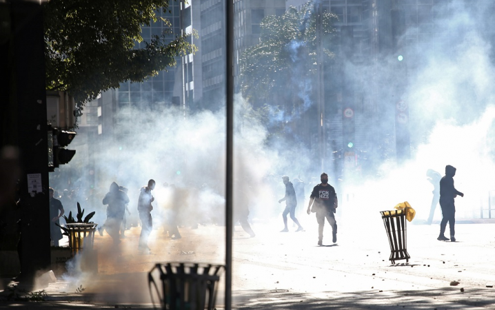 Manifestantes são vistos entre gás lacrimogêneo durante um protesto contra o presidente brasileiro Jair Bolsonaro na avenida Paulista