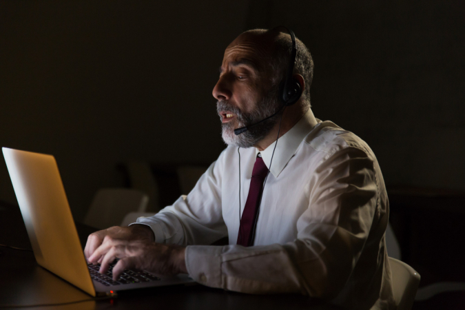 businessman-in-headset-talking-and-using-laptop(1)