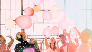 Pessoas brinca com balões em festa de aniversário