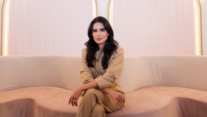 A empresária Natalia Martins, toda de rosa, sentada em um sofá