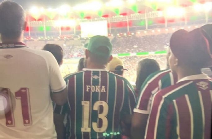 Torcedores do Fuminense de costas na arquibancada do Maracanã. entre eles Foka, que leva seu nome na camisa e o número 13