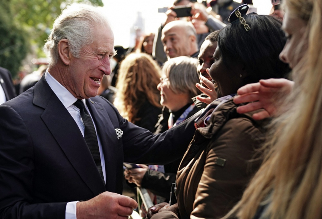 O rei Carlos III da Grã-Bretanha conversa com o público que espera na fila para prestar homenagem à rainha Elizabeth II,