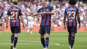 Lewandowski comemora juntando os punhos enquanto dois companheiros estão de costas