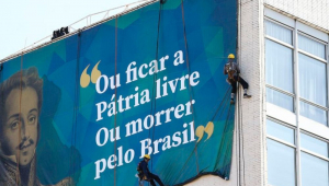 Imagem de Dom Pedro I em lona colocada na Esplanada dos Ministérios com uma frase: "Ou ficar a pátria livre ou morrer pelo Brasil"