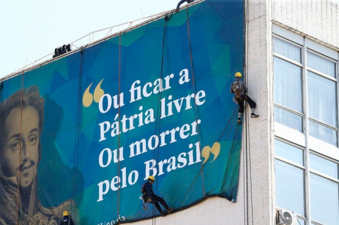 Imagem de Dom Pedro I em lona colocada na Esplanada dos Ministérios com uma frase: 