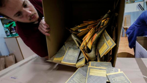Homem virando caixa com votos das eleições na Itália