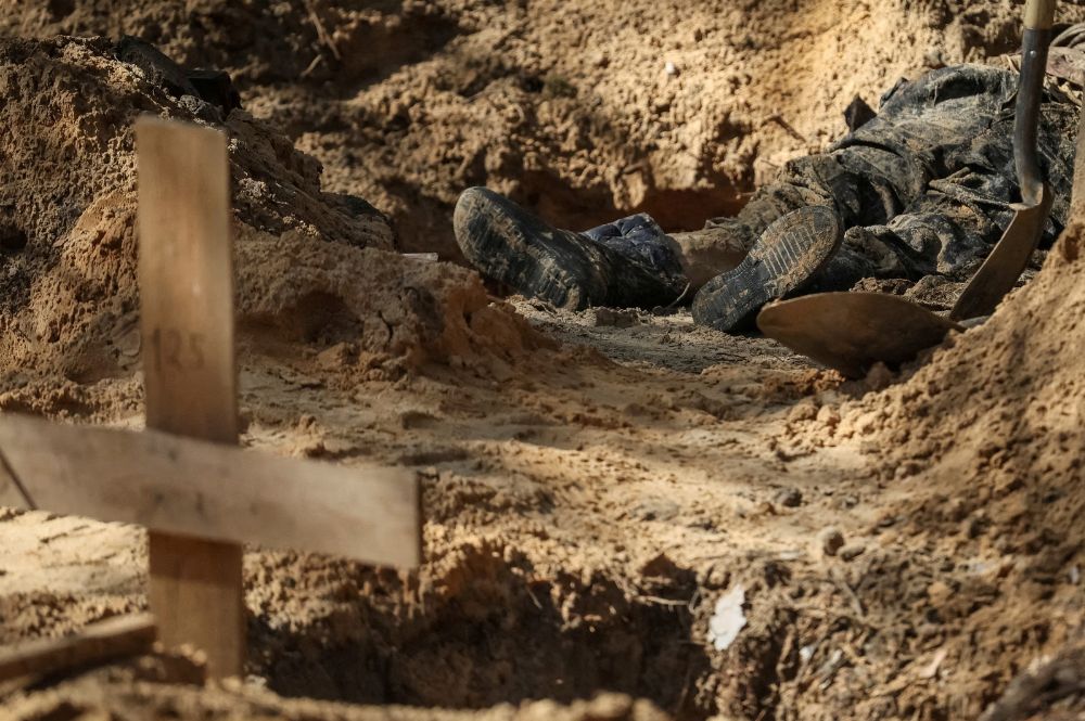 Um corpo exumado jaz no túmulo de um cemitério improvisado, enquanto o ataque da Rússia à Ucrânia continua, na cidade de Izium, recentemente libertada pelas Forças Armadas Ucranianas, na região de Kharkiv, Ucrânia 17 de setembro de 2022.