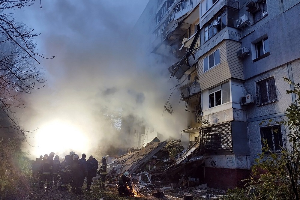 Equipes de resgate se reúnem em frente a um prédio residencial danificado após um ataque em Zaporizhzhia, em meio à invasão russa da Ucrânia em 9 de outubro de 2022