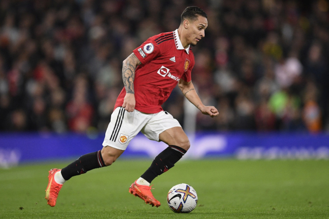 Antony carregando a bola durante partida do Manchester United