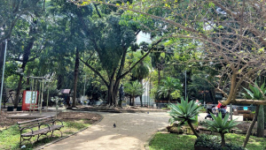 Praça em São Paulo com área verde, bancos, espaço para exercícios e um monumento