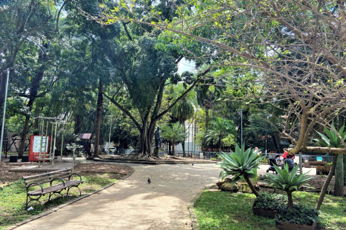 Praça em São Paulo com área verde, bancos, espaço para exercícios e um monumento