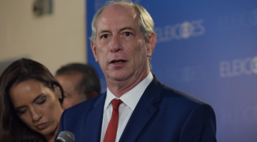 Ciro Gomes usa camisa branca, gravata vermelha e terno azul durante coletiva