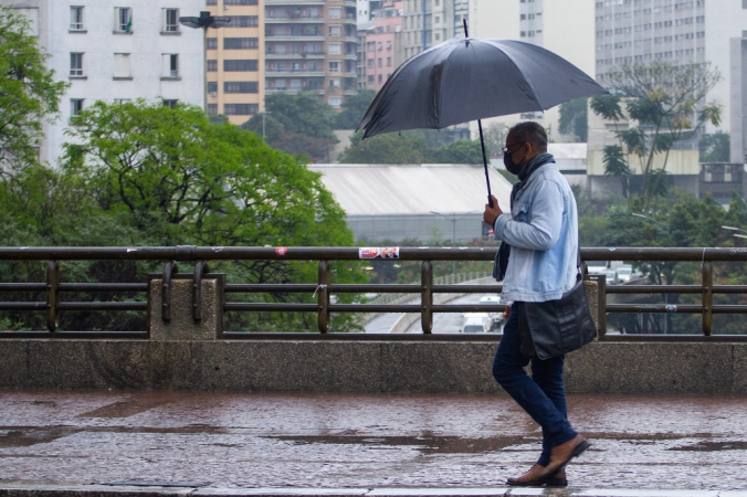 Pedestre se protegem da chuva no viaduto do Chá, região central da cidade de São Paulo