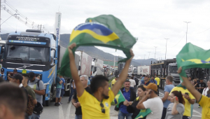 Caminhoneiros, muitos com bandeiras do Brasil, protestam em rodovia