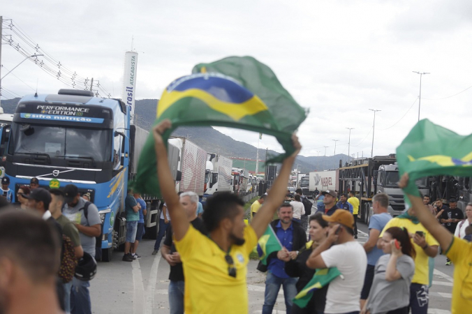 Caminhoneiros, muitos com bandeiras do Brasil, protestam em rodovia