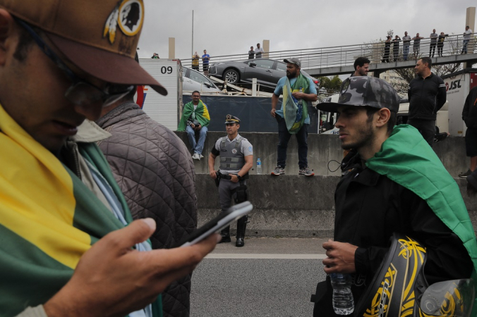 Um policial monta guarda enquanto apoiadores do presidente Jair Bolsonaro bloqueiam a rodovia Castelo Branco,