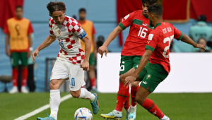 Com a bola dominada, Modric tenta passar pr dois jogadores marroquinos