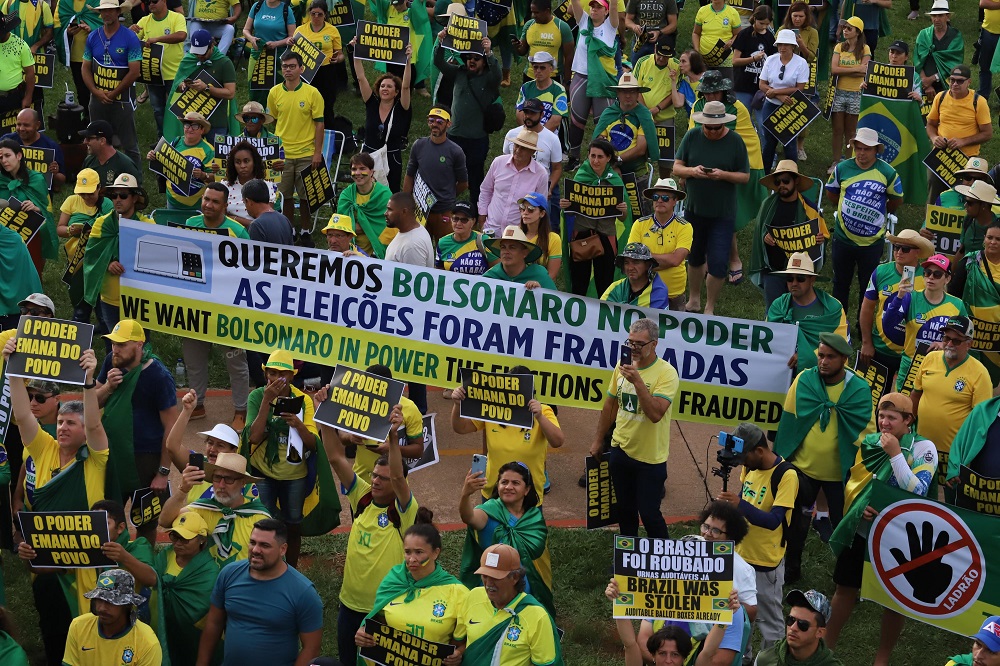 Manifestantes de amarelo levantam cartazes e faixas contra Lula e o processo eleitoral