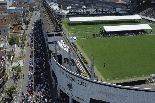Fãs da lenda do futebol brasileiro Pelé se reúnem do lado de fora do estádio Urbano Caldeira