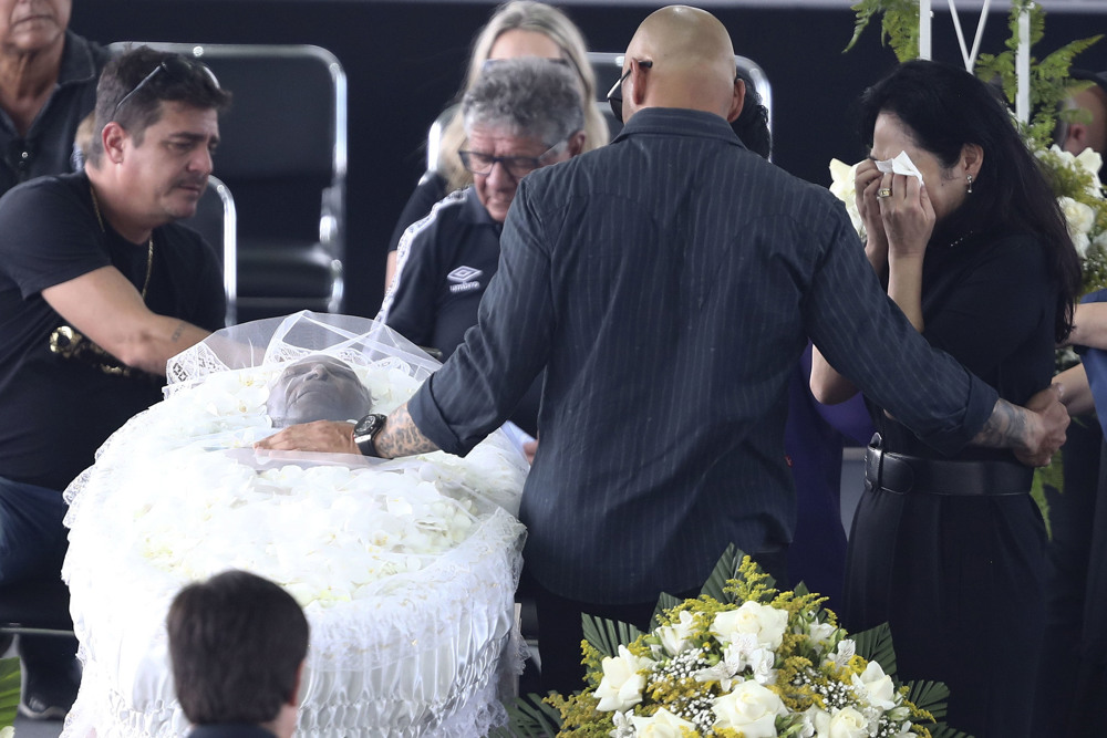 Edson Arantes do Nascimento, o Rei Pelé, é velado da Vila Belmiro; sua esposa, Márcia Aoki, chora ao lado do caixão