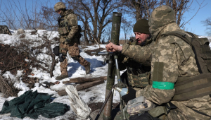 Militares ucranianos se preparam para disparar um morteiro em direção à posição russa