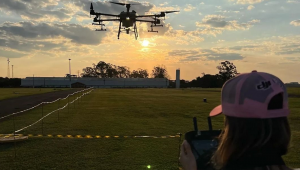 Mulher opera drone em campo aberto durante o fim de tarde