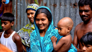 Família indiana, destacando-se uma mãe com o filho no colo