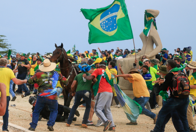 Um policial militar cai de seu cavalo durante confrontos manifestantes após uma invasão ao Palácio Presidencial do Planalto