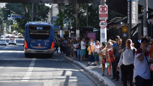 Aglomeração de pessoas esperando ônibus