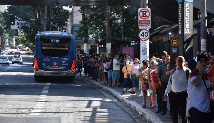 Aglomeração de pessoas esperando ônibus