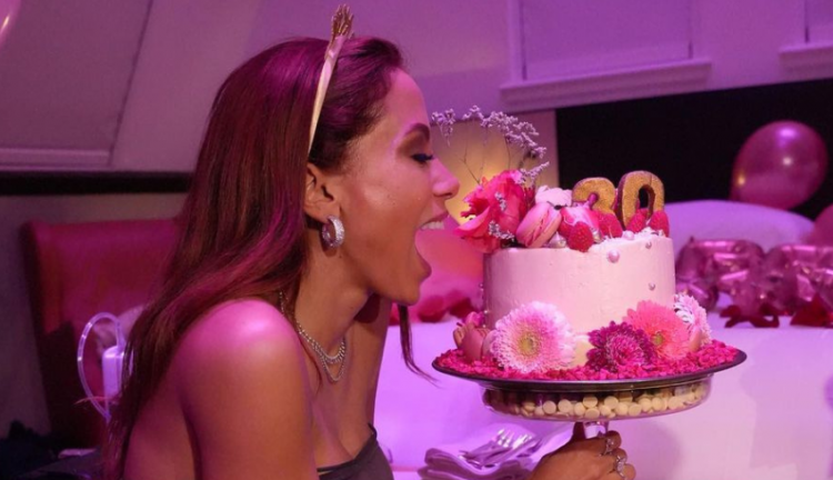 Anitta segurando um bolo de aniversário
