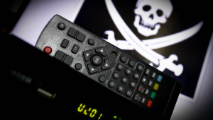TV Box, controle remoto de TV e imagem de pirata na tela