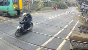 motociclista se salvando de ser atingido por trem