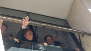 O ex-presidente Jair Bolsonaro acena de uma janela na sede do PL, no centro de Brasília, na manhã desta quinta-feira, 30