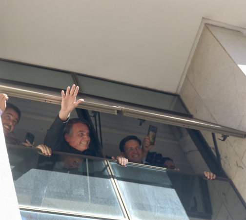 O ex-presidente Jair Bolsonaro acena de uma janela na sede do PL, no centro de Brasília, na manhã desta quinta-feira, 30