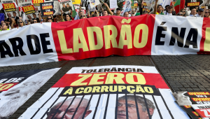 Manifestantes protestam contra o presidente brasileiro Luiz Inácio Lula da Silva durante sua visita a Portugal, em frente ao parlamento em Lisboa