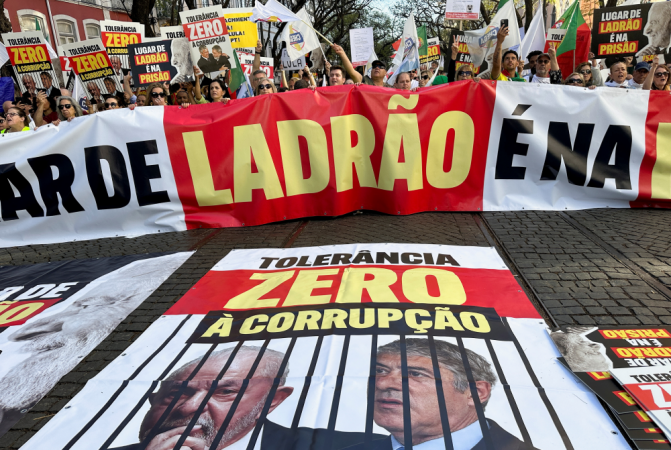 Manifestantes protestam contra o presidente brasileiro Luiz Inácio Lula da Silva durante sua visita a Portugal, em frente ao parlamento em Lisboa