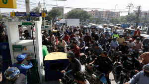 Pessoas em motocicletas esperam a vez de abastecer em um posto de gasolina em Karachi, Paquistão