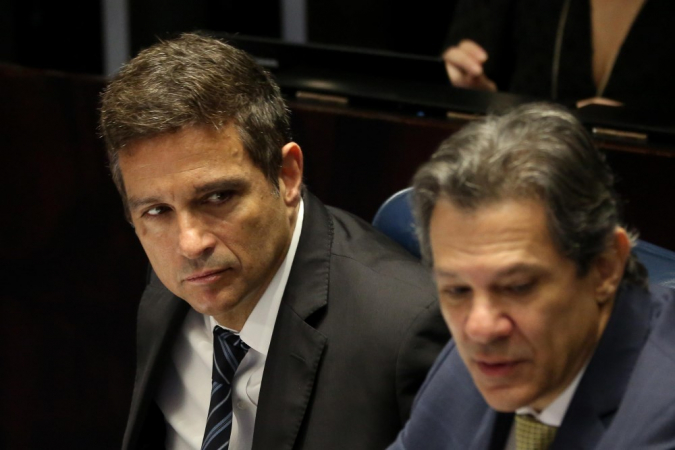 Campos Neto e Haddad sentados lado a lado durante sessão no Senado