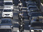 Imagem de trânsito com motos entre os carros
