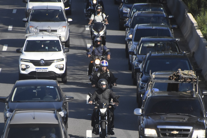 Imagem de trânsito com motos entre os carros