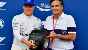 O piloto finlandês da Mercedes, Valtteri Bottas (à esquerda), recebe o "prêmio da pole position" da ex-lenda do automobilismo brasileiro Nelson Piquet (à direita)