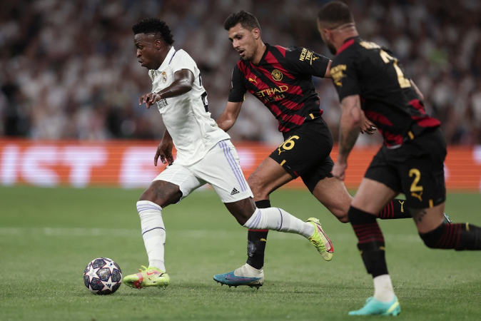 Vinicius Júnior tenta escapar da marcação no duelo entre Real Madrid e Manchester City