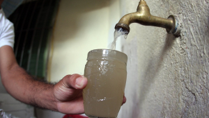 Água com cor escura saindo da torneira, denotando falta de saneamento básico