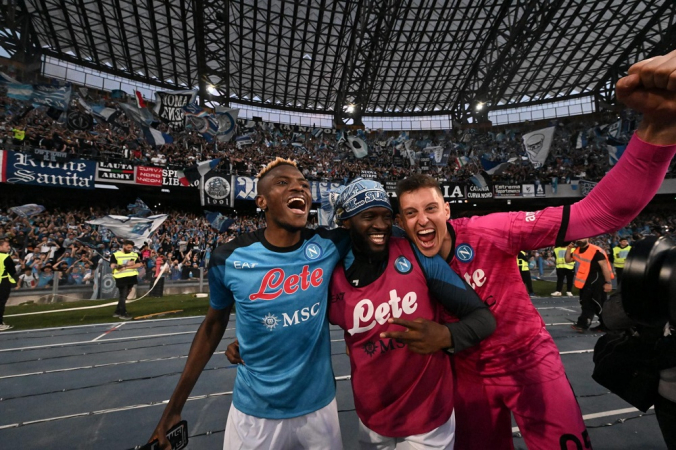 Victor Osimhen (esquerda), do Napoli, comemora com os companheiros a conquista do tricampeonato nacional, o Scudetto, após vencer o SSC Napoli x ACF Fiorentina, pela Serie A, em Nápoles