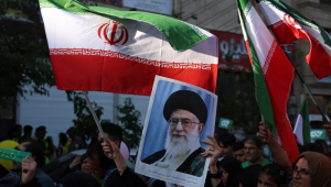 Mulher iraniana segura um cartaz com a imagem do líder supremo do Irã, aiatolá Ali Khamenei
