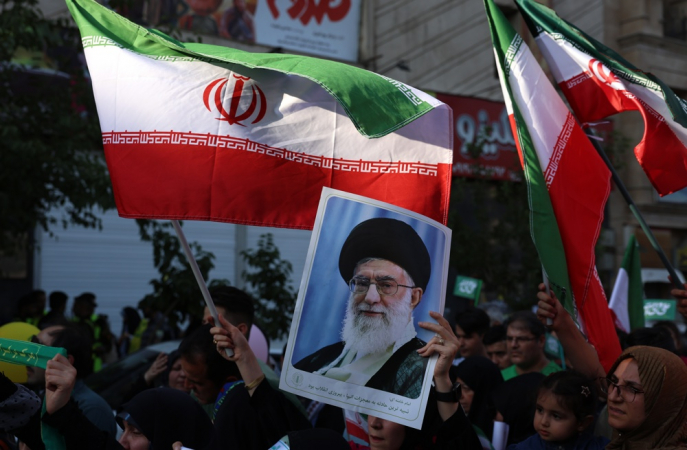 Mulher iraniana segura um cartaz com a imagem do líder supremo do Irã, aiatolá Ali Khamenei
