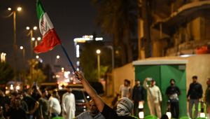 Uma manifestante empunha uma bandeira do Irã durante um protesto contra o ataque de Israel ao país