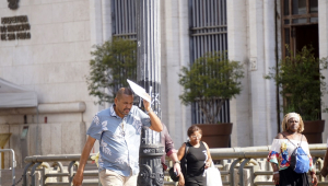 Pedestre se protege do sol no Viaduto do Chá, na região central de São Paulo