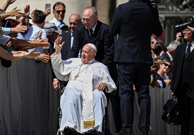 O Papa Francisco acena para os participantes ao sair no final da audiência geral semanal